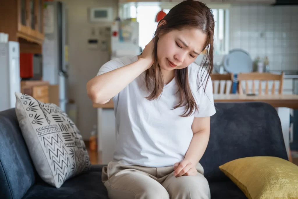 首をおさえる女性